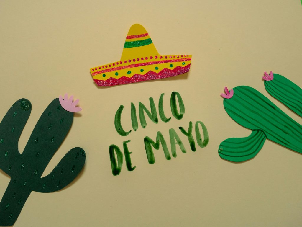Festive Cinco de Mayo illustration featuring cacti and a sombrero.